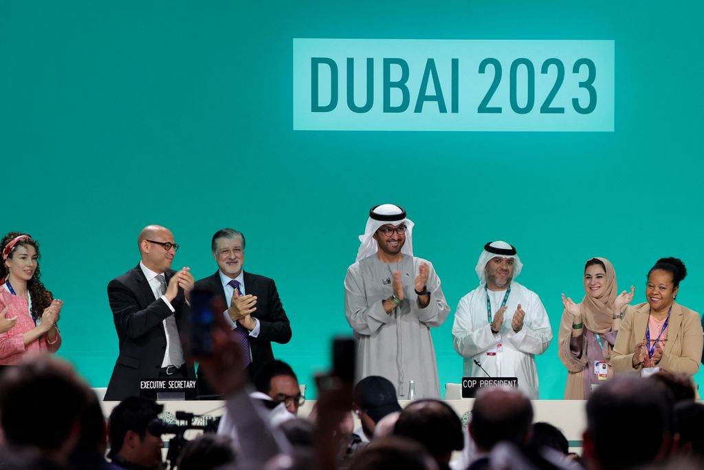 A row of people standing and applauding on stage