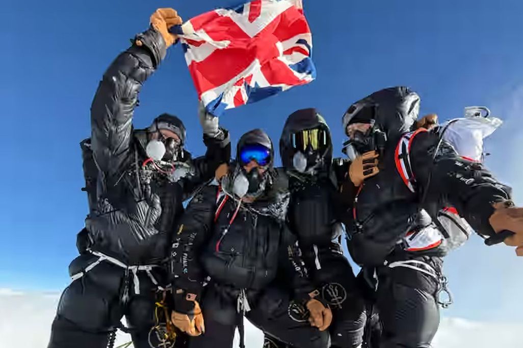 Four men holding up a British flag
