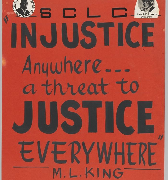 A black ink on a red-orange poster board with a small picture of Martin Luther King, Jr. at the top left and Joseph Lowery at the top right. The poster reads: [SCLC / INJUSTICE / Anywhere... / a threat to / JUSTICE / EVERYWHERE / M. L. KING].