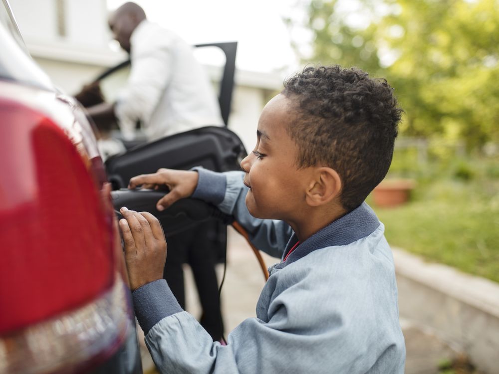 boy charges electric vehicle