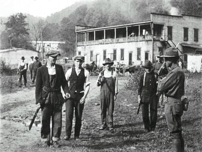 Three miners with federal soldier prepare to surrender weapons.