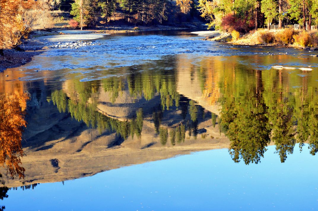 Little Vulcan Mountain is reflected in the clear, autumn waters of the