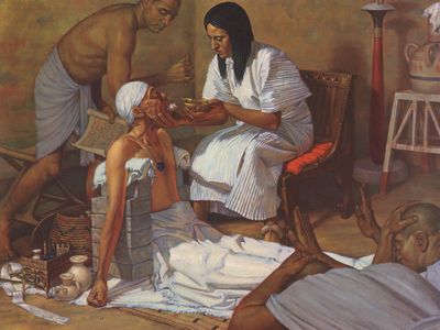 A lithograph depicting an ancient Egyptian physician treating a patient for lockjaw. In the village of Deir el-Medina, this man may have still been paid while missing work.

