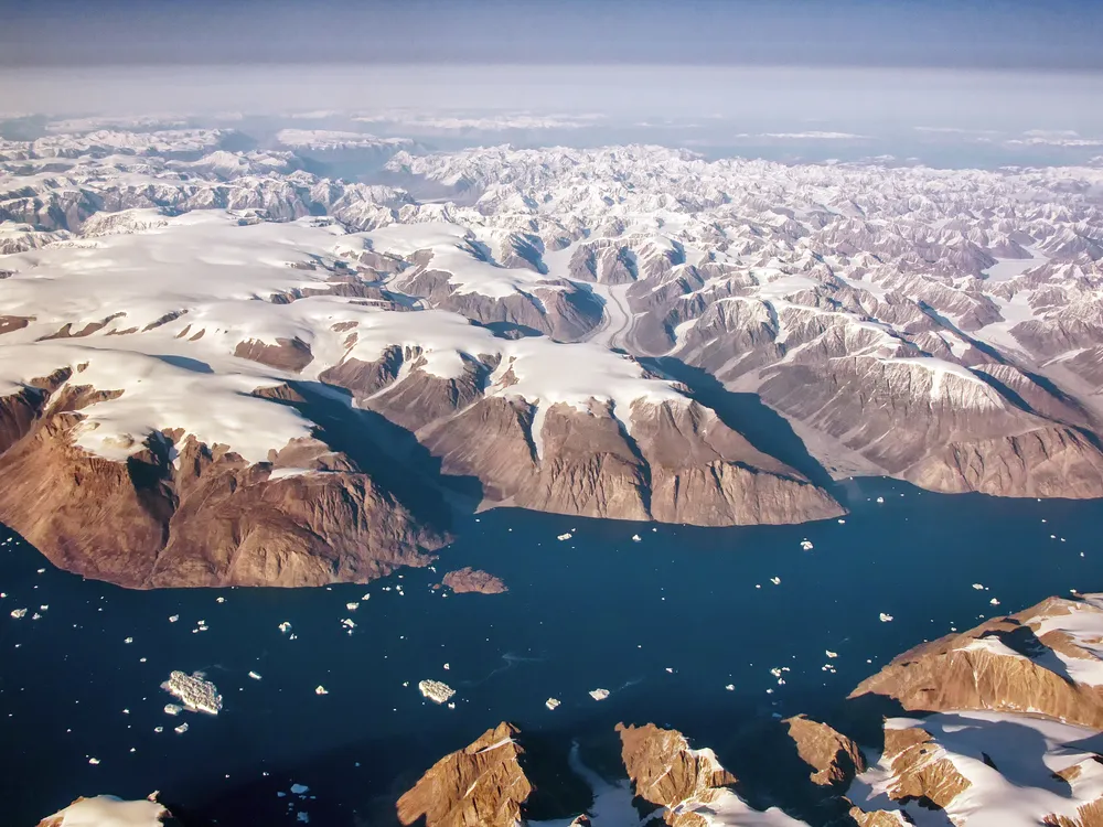 An aerial view of Greenland's snowy fjords, glaciers and mountains