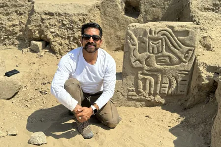 Luis Muro Yno&ntilde;&aacute;n poses with a carving of a mythological bird-like creature.