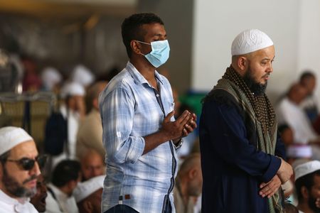 Worshippers, some of them wearing protective masks, take part in the Friday prayers at Mecca's Grand Mosque on March 6, 2020, a day after Saudi authorities emptied Islam's holiest site for sterilization.