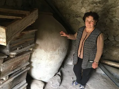 Asli Saghatelyan stands next to her father-in-law’s 240-gallon karas, a clay vessel traditionally used in Armenia, until recently, for storing and fermenting homemade wine.