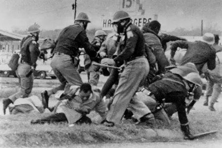 An Alabama State Trooper swings his baton at the head of the then-25-year-old Congressman John Lewis on March 7, 1965.