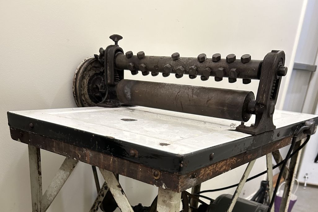 Machine with two rollers atop a counter