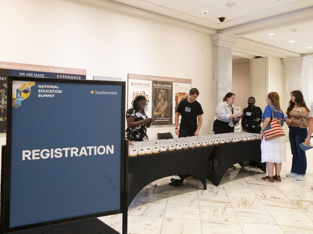 A sign says Registration and a group of people approach a table