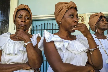 These women in traditional dress are preparing for a street performance in Havana. Despite laws guaranteeing racial equality, black Cubans are generally poorer than whites. And with fewer relatives abroad, they typically receive less in remittances.