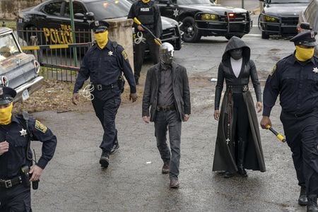 In a scene from the HBO series, Tulsa’s masked police force prepares for a raid. Detective Wade Tillman (known as “Looking Glass”) is played by Tim Blake Nelson. Detective Angela Abar (known as “Sister Night”) is played by Regina King (Mark Hill for HBO).