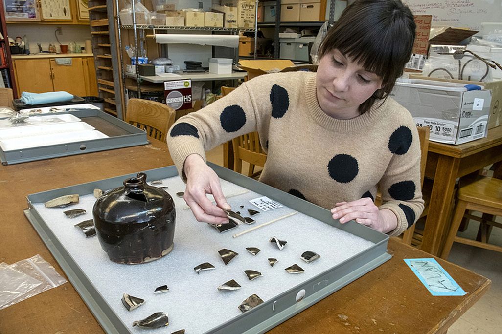 Archaeologist examines fragments of Chinese pottery