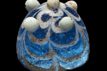 A piece of worked glass unearthed from the English island of Lindisfarne that researchers suspect may have once been a Viking game piece