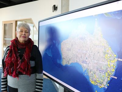 Professor Lyndal Ryan poses with the online map of colonial Frontier massacres in Eastern Australia. 