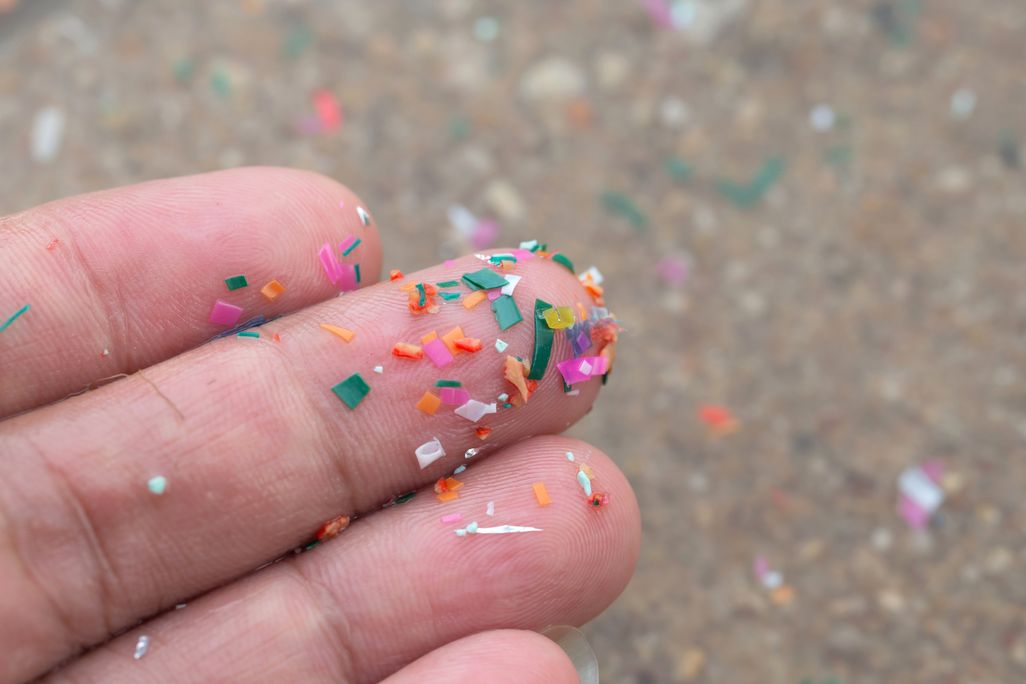 Colorful bits of plastic on fingertips