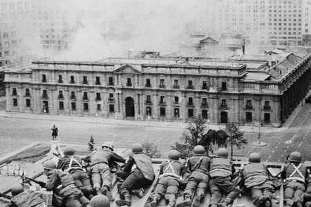 Soldiers supporting the coup led by Gen. Augusto Pinochet take cover as bombs are dropped on the Presidential Palace of La Moneda in Sept. 11, 1973.