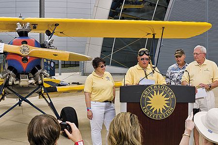 An emotional Gene Breiner (at lectern, with daughter Joyce and General Jack Dailey, director of the National Air and Space Museum) donated Plane Jane to the Museum this past June in hopes of inspiring future pilots.