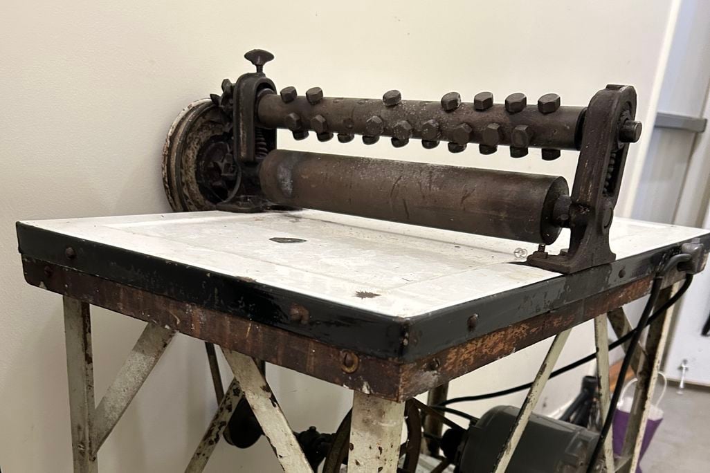 Machine with two rollers atop a counter