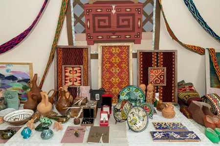 Several pieces of textiles, pottery, and other artwork arranged in an altar.