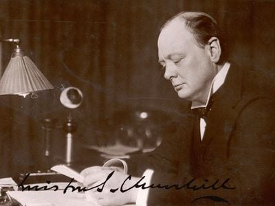 British statesman and author Winston Churchill reads correspondence at his desk in 1933.