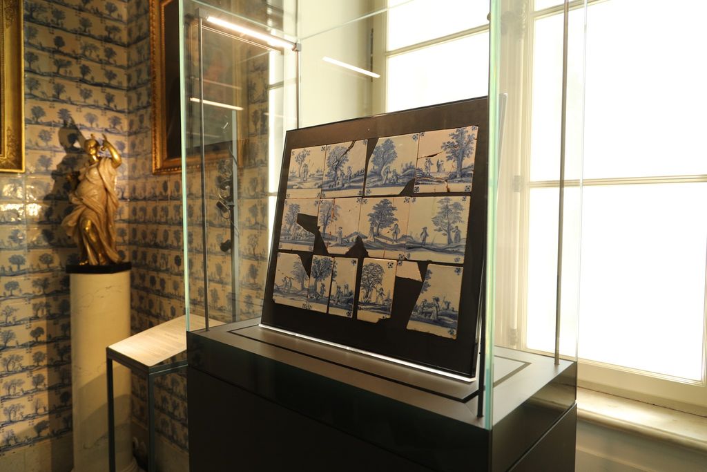 Cracked and broken tiles inside a display case in a museum