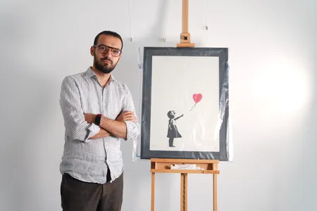 Lindor Mehmetaj, the manager of&nbsp;London&#39;s Grove Gallery,&nbsp;with Banksy&#39;s Girl With Balloon