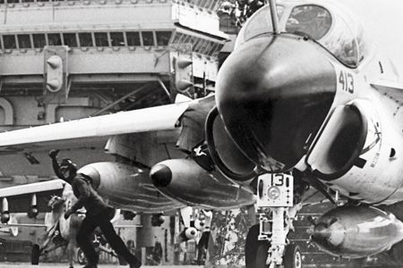 On the USS Constellation late in 1968, a catapult crewman gives the signal that an A-6 is ready to launch. A centerline D-704 refueling store augmented the four drop tanks beneath the wings. The D-704’s propeller, driven by wind in flight, powered a motor that extended and retracted its refueling hose.