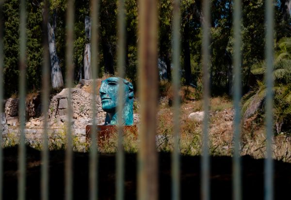Statue head behind bars of an Ancient Greek theatre thumbnail