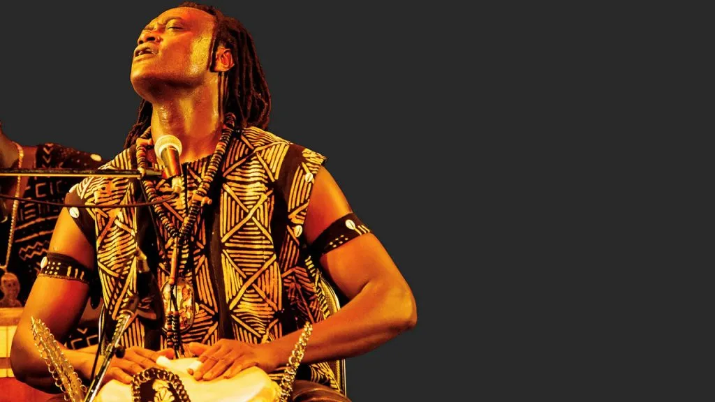 Latyr Sy, a Senegalese percussionist and singer, plays the drums.