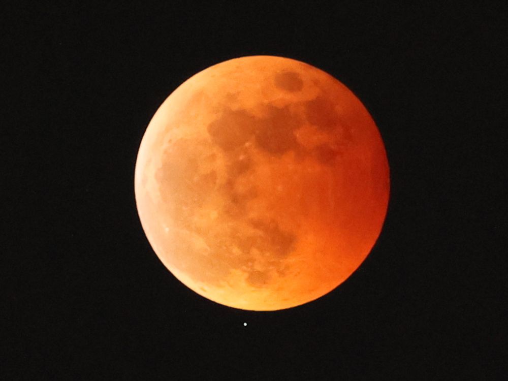 the moon appears orange and red in a lunar eclipse