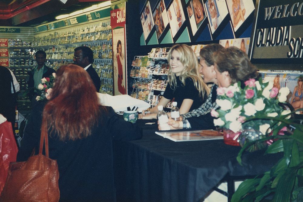 Claudia Schiffer sitting at a table