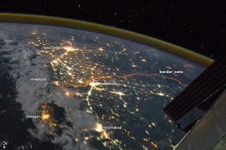 India’s northwestern boundary with neighboring Pakistan is so brightly lit that the thin orange line tracing its path can be seen from space.