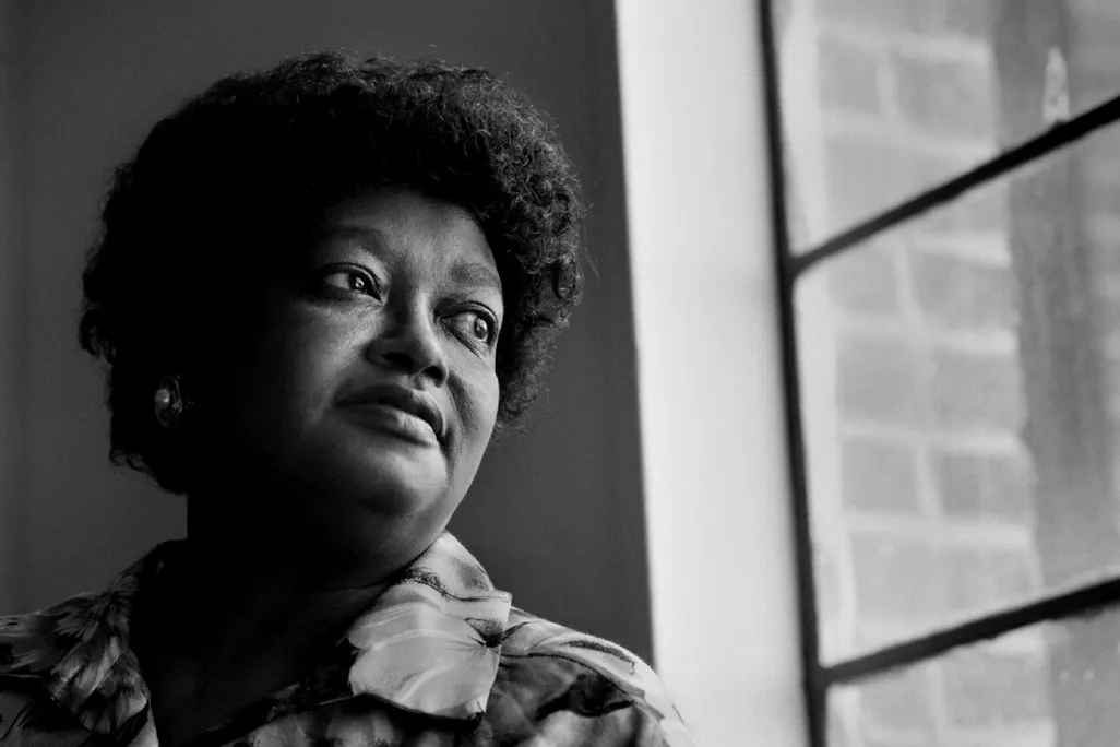 A portrait of a Black woman gazing out a window