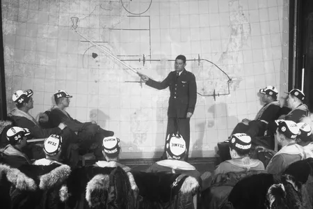 Major Harry B. Bailey, an intelligence officer for the 98th Bomb Group, briefs a B-29 crew on hitting a target in Sinuiju, North Korea with conventional bombs. The city was heavily damaged but has since been rebuilt.
