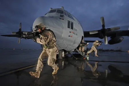 Air Force Staff Sgt. Tony Rivera and Senior Airmen Jason Bauer and Darryll Morley (all with the 332nd Expeditionary Security Forces Squadron) provide security for a C-130 Hercules at Balad Air Base, Iraq, January 2006.