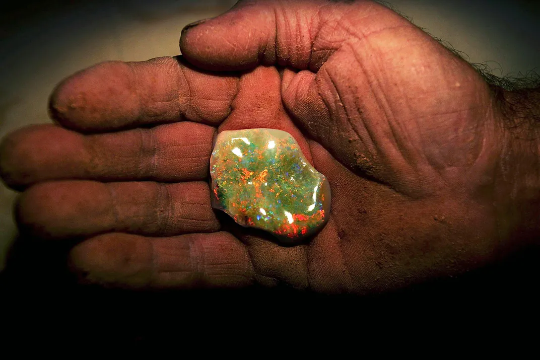 Coober Pedy miner holds a finished opal