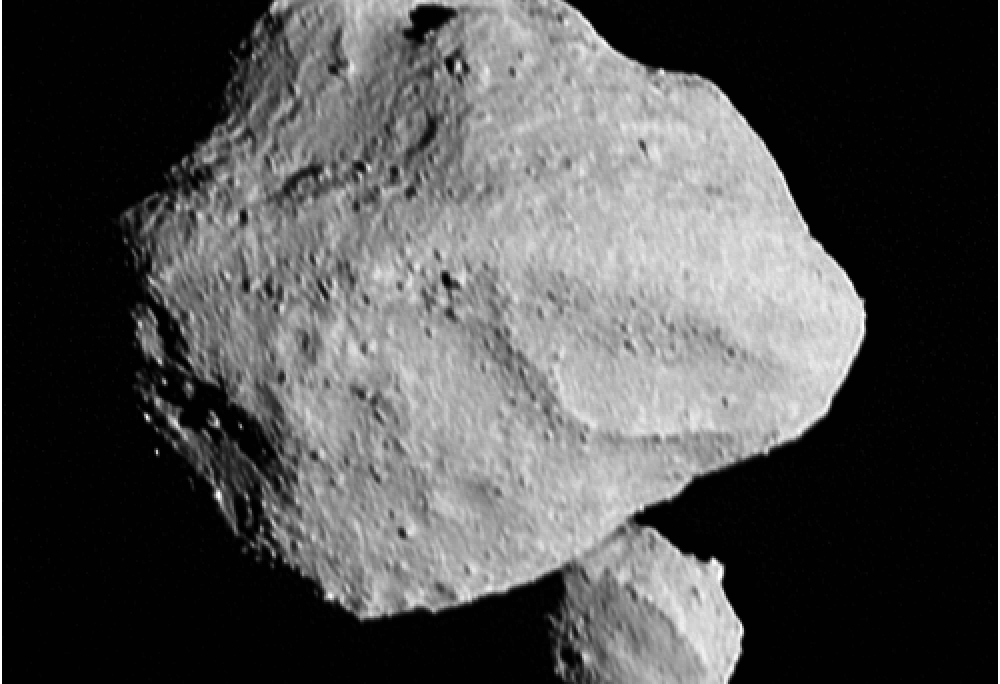 A black and white photo of an asteroid with a second smaller asteroid below and behind it