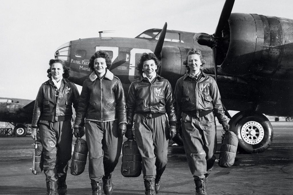 Women Airforce Service Pilots (left to right) Frances Green, Margaret Kirchner, Ann Waldner, and Blanche Osborn pass a line of Boeing B-17s