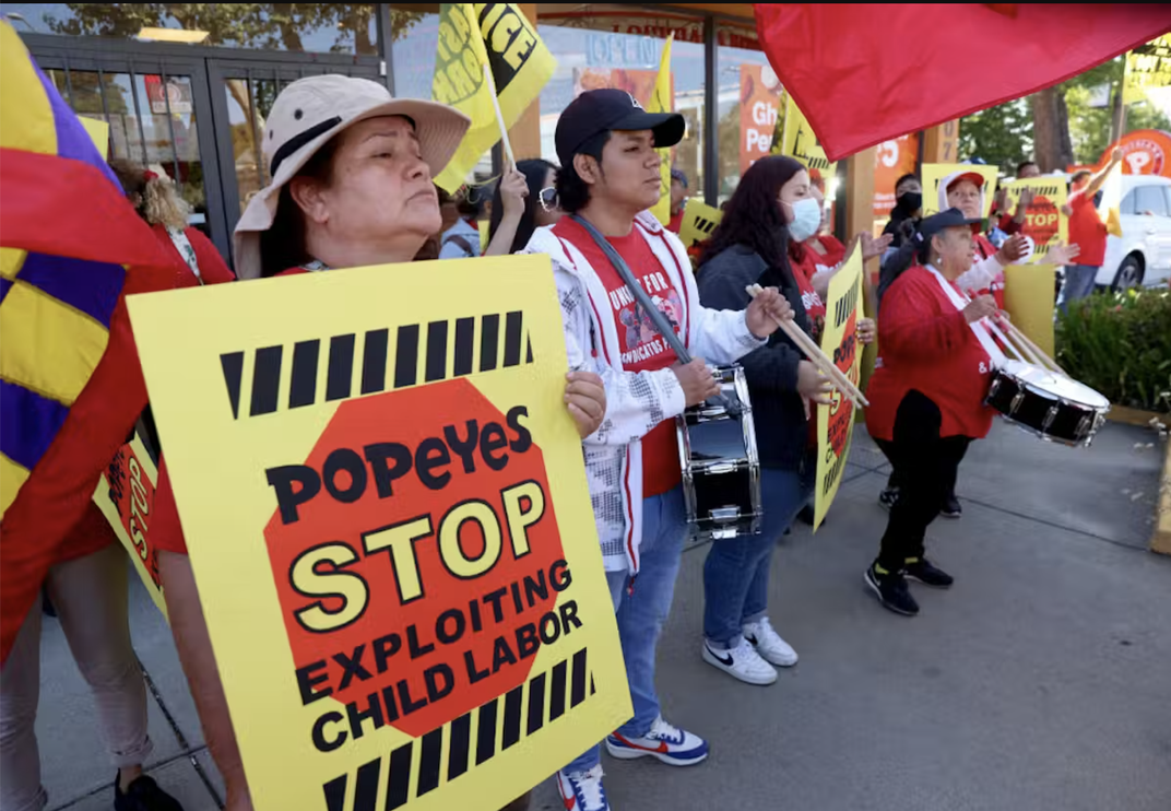 Workers protest outside a Popeye’s restaurant in Oakland, California, on May 18, 2023, after reports emerged of the franchise exploiting child labor.