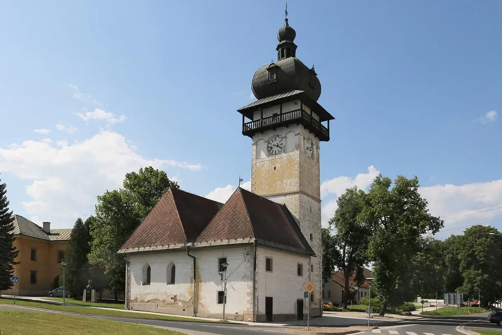 One tall tower with a domed black roof, next to two small buildings