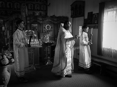 Inside the Church of Saint Nicholas, Father Nikolai Yakunin blesses parishioners during Pascha (Russian Easter), which begins at midnight and ends at dawn. The smoke of the incense is said to lift prayers to heaven.
