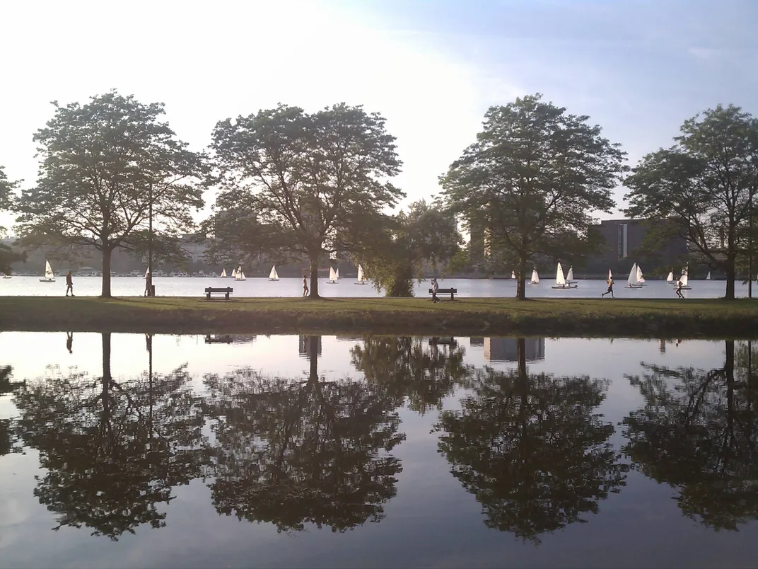 Runners enjoy the view of sailboats on the esplanade near the Charles River.