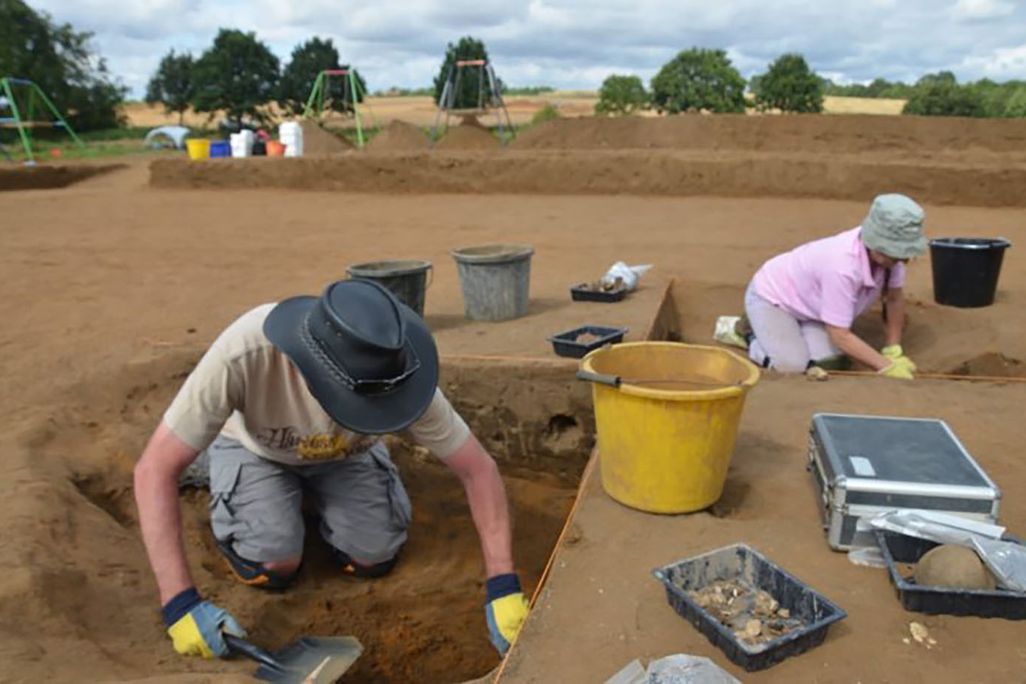 Archaeologists digging in sediment searching for artifacts at a dig in Rendlesham