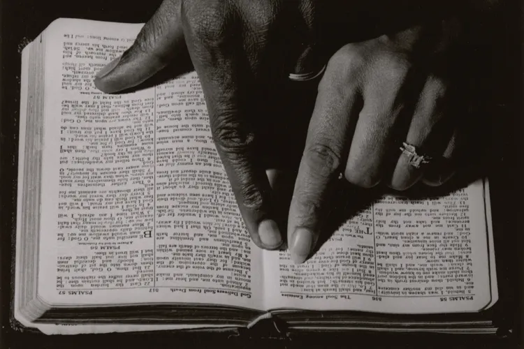 Two hands pointing to a Bible passage, ca. 1968