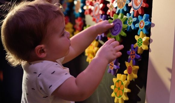 Young child experiences hands-on play experience with objects