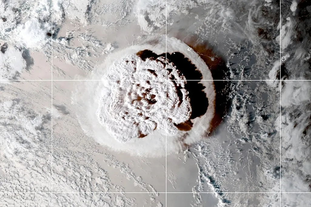 A satellite image of a mushroom cloud of ash from a volcano eruption in the pacific