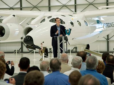 Standing in front of WhiteKnightTwo, George Whitesides addresses a crowd at Virgin Galactic's hangar at the Mojave Air and Space Port in California.