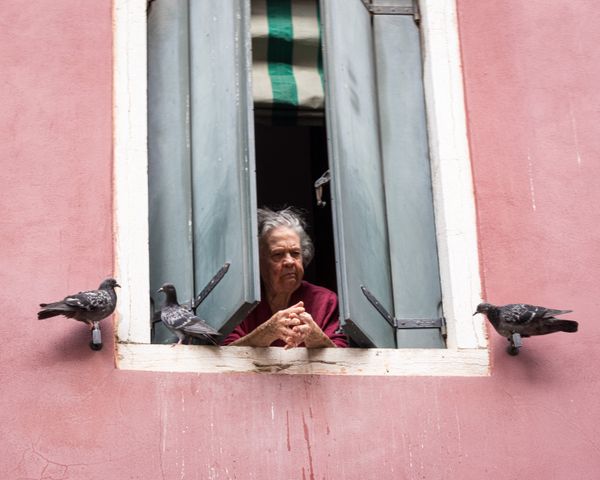 An old woman looking out of her window thumbnail