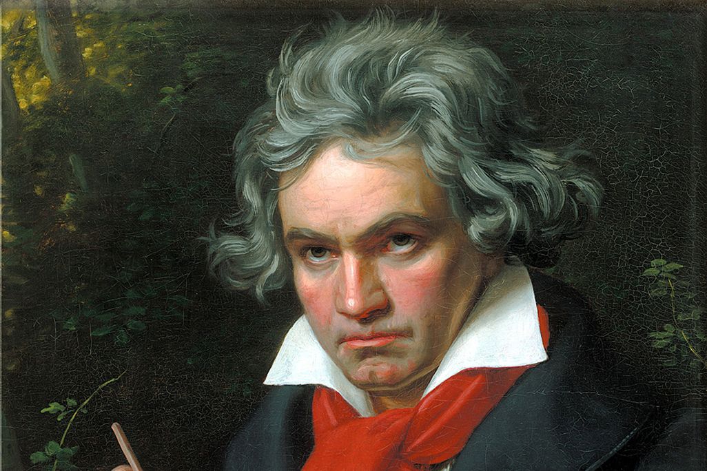 A portrait of Beethoven, a white man with reddish cheeks holding a musical score and a pencil in his hand, wearing a red scarf around his neck with tousled, unruly hair